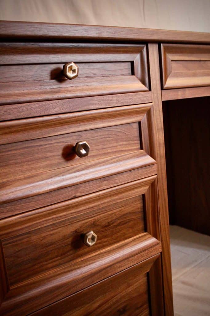 Close up of brown dresser with golden handles